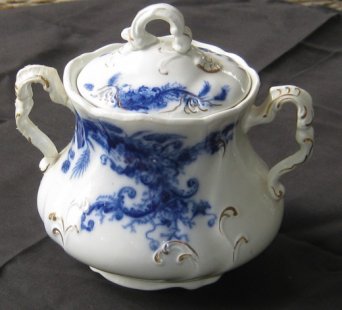 A Flow Blue sugar bowl by Wentworth. An intact sugar bowl is more valuable than, say, a plate. The sugar bowl has more parts that can break, so the intact handles and lid make this a valuable item.